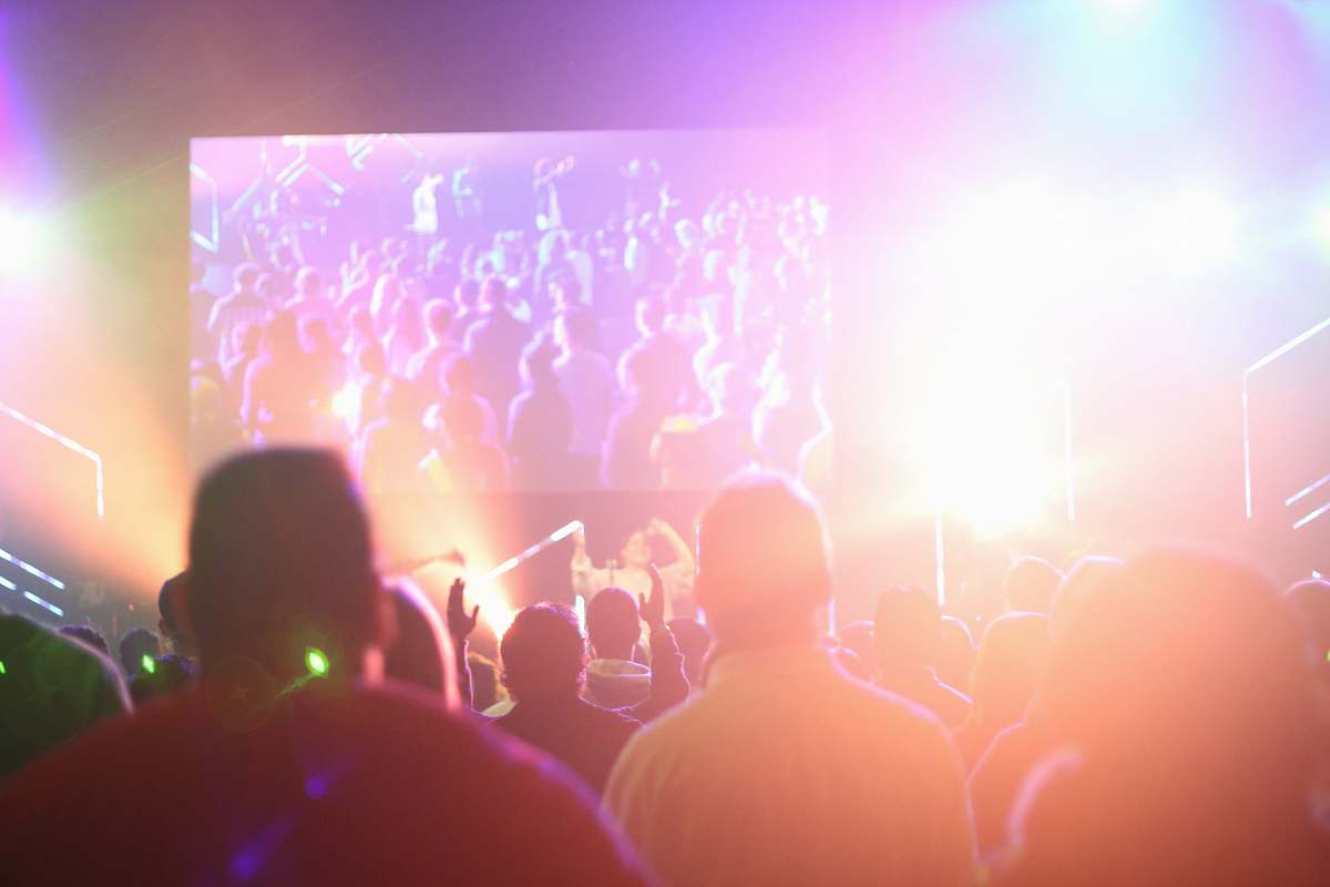 leisure activities group of people having a party inside dark room with light effects crowd